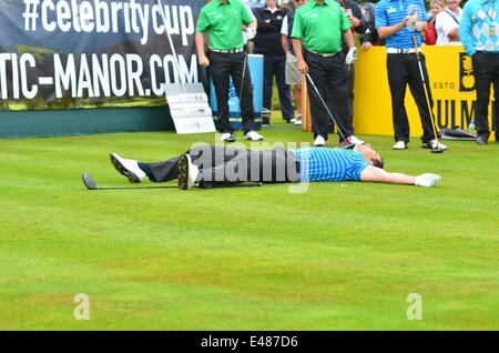 Newport, Wales. July 5th 2014. Geraint Hardy lies on the Teeing area, after his drive to the roar and laughter of the Crowd  at The Celebrity Cup at the Celtic Manor Resort in Wales. ROBERT TIMONEY/Alamy LiveNews. Stock Photo