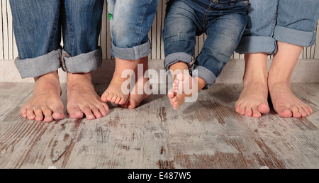 dad, mom and daughters barefoot in jeans Stock Photo