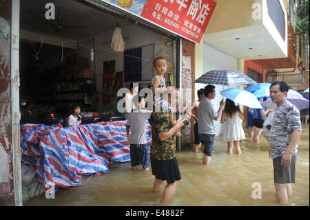 (140705) -- MASHAN, July 5, 2014 (Xinhua) -- People stand in flood water in Mashan County, south China's Guangxi Zhuang Autonomous Region, July 5, 2014. Torrential rain hit Guangxi since July 4, where the precipitation exceeded 100 mm in 21 counties. (Xinhua/Zhang Ailin) (hdt) Stock Photo