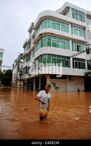 (140705) -- MASHAN, July 5, 2014 (Xinhua) -- A man walks in flood water in Mashan County, south China's Guangxi Zhuang Autonomous Region, July 5, 2014. Torrential rain hit Guangxi since July 4, where the precipitation exceeded 100 mm in 21 counties. (Xinhua/Zhang Ailin) (hdt) Stock Photo