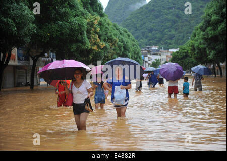 (140705) -- MASHAN, July 5, 2014 (Xinhua) -- People leave for safe places in Mashan County, south China's Guangxi Zhuang Autonomous Region, July 5, 2014. Torrential rain hit Guangxi since July 4, where the precipitation exceeded 100 mm in 21 counties. (Xinhua/Zhang Ailin) (hdt) Stock Photo