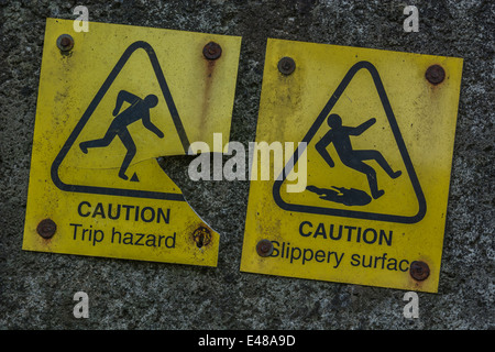 Close detail of two accident warning signs for 'trip' and 'slipping'. Falling man pictogram. Stock Photo