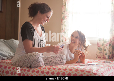 Mother and daughter playing cards on bed