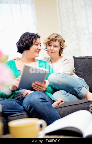 Female couple sitting on sofa Stock Photo