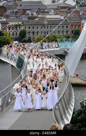 Derry, Londonderry, Northern Ireland UK, - 05 July 2014. Brides gather for world record attempt. Hundreds of blushing brides, of all ages walk across the Derry Peace Bridge in an attempt to create a new world record for the number of brides gathered in one place. Last year 748 brides, including a few men, walked across the Peace Bridge gaining a place in the Guinness Book of Records. Credit: George Sweeney / Alamy Live News Stock Photo