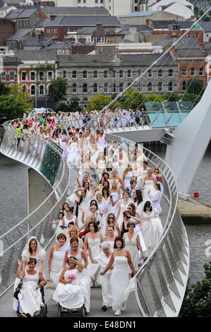 Derry, Londonderry, Northern Ireland UK, - 05 July 2014. Brides gather for world record attempt. Hundreds of blushing brides, of all ages walk across the Derry Peace Bridge in an attempt to create a new world record for the number of brides gathered in one place. Last year 748 brides, including a few men, walked across the Peace Bridge gaining a place in the Guinness Book of Records. Credit: George Sweeney / Alamy Live News Stock Photo