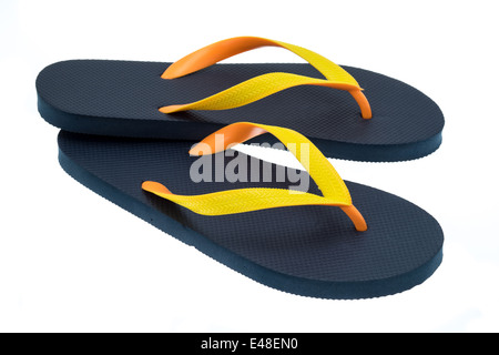Black thong type flip-flops with orange and yellow straps - studio shot with a white background Stock Photo