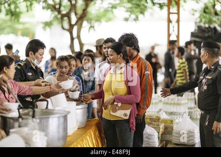 June 16, 2014 - Aranyaprathet/Poipet, Sa Kaeo Province, Thailand - Cambodian migrant workers are fed by the Thai military before they cross the border and return to their homes in Cambodia during a mass exodus, Aranyaprathet Town Centre, Aranyaprathet/Poipet, Thailand. Fearing a crackdown on illegal immigration from the Thai military, over 120,000 Cambodian migrants are reported to have crossed the border and returned to Cambodia in one week. Estimates suggest that at least 150,000 legal and illegal migrants from Cambodia were working in Thailand before the exodus, typically in the constructio Stock Photo