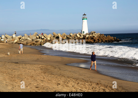 Lady walking on seabright beach, on east cliff near Breakwater Lighthouse, in beautiful Santa Cruz,  California Stock Photo