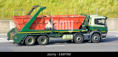 Lorry loaded with two skips driving along motorway (name on skips removed) Stock Photo