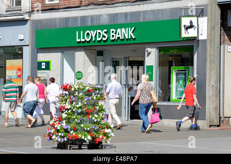 Lloyds Bank High Street Brentwood Essex England UK branch pavement floral display & wall plaque for worlds first on line real time atm cash machine Stock Photo