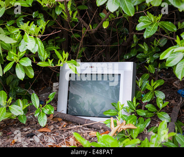 Old broken computer dumped in the bushes outside the closed and disused Mereway Day Centre in Twickenham, UK Stock Photo