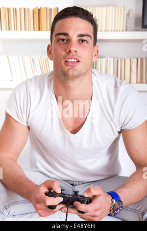 attractive guy concentrating while playing video games at home Stock Photo