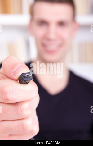 man holding and showing black micro USB cable, micro usb port connector Stock Photo