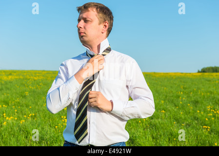 man in white shirt straightens his tie Stock Photo