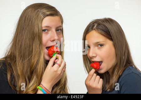 Two teenage girls eating strawberries Stock Photo