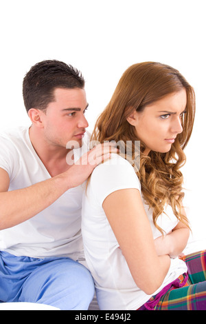 young woman ignoring her man partner in her bed during a conflict, turning their back on each other Stock Photo