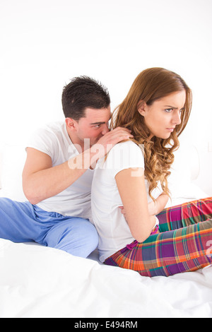 pretty young woman ignoring her man partner in her bed during a conflict Stock Photo