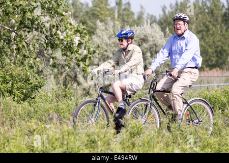 Senior citizen couple cycling through the Leslie St Spit or Tommy Thompson Park in Toronto Ontario Stock Photo