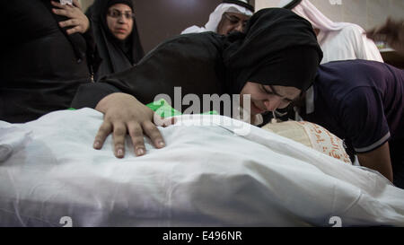 Sanabis, Bahrain. 6th July, 2014. martyr wife during the last farewell, noted that Abdul Aziz Al Abbar was killed by a gunshot fired by Bahraini security forces on February 23 and entered the hospital for 55 days and announced his death on April 18 where authorities detained his body for a period of 78 days, Tens of thousands of bahrainis participat in the funeral march ( Photo by Hussain Albahrani/Pacific Press/Alamy Live News) Stock Photo