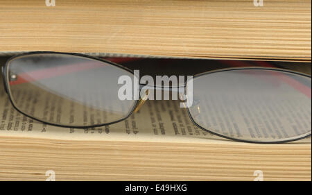 Eyeglasses on the betwixt pages old book.