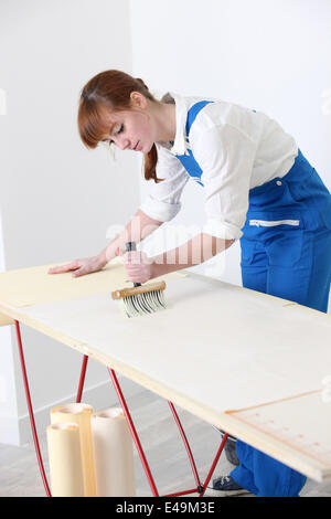 Female decorator pasting wallpaper Stock Photo