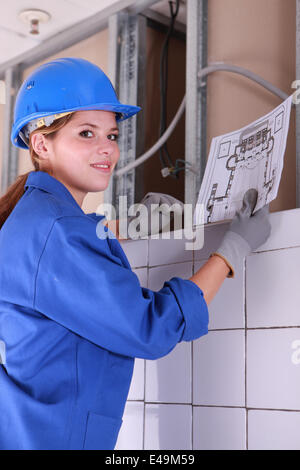 Female electrician looking at a diagram Stock Photo