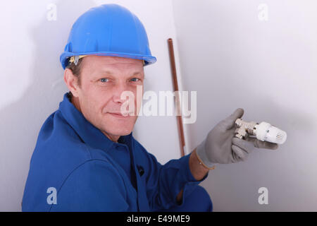 Plumber with a thermostatic radiator valve Stock Photo