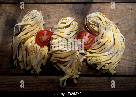 Fresh unwrought tagliatelle and tomatoe Stock Photo