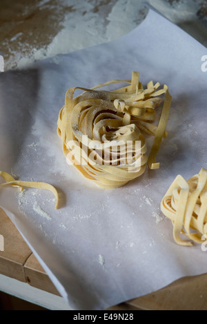 Fresh unwrought tagliatelle and flouron baking paper Stock Photo