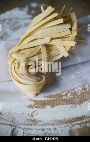 Fresh unwrought tagliatelle and flouron baking paper Stock Photo