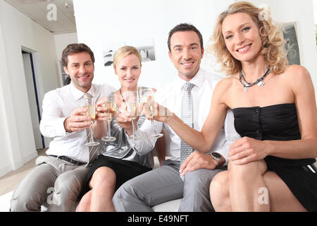 couples sitting holding champagne glasses Stock Photo