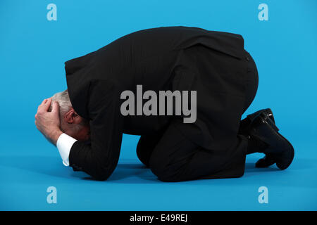 Businessman huddled on the floor Stock Photo