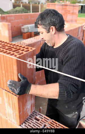 Bricklayer building wall Stock Photo