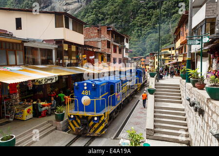 Train crossing the town of Aguas Calientes, Peru, South America Stock Photo