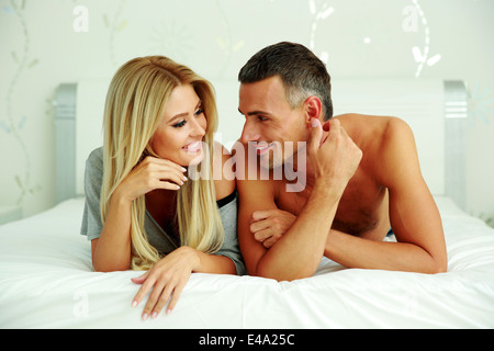 Happy couple lying on the bed at home Stock Photo