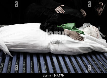 Sanabis, Bahrain. 6th July, 2014. Bahrain, Sanabis - women in the last moments with the martyr, Thousands attend the funeral of Abdul Aziz al-Abbaar in the village of Sanabis west of the capital Manama, Abdulaziz was hit in his head by a tear gas canister and birds bullets shot on February 23rd when he was taking a part in clashes with riot police and died from wounds on April 18th, Al-Abbar's body was in the morgue for 76 days because his family refused to sign the death certificate which ministry of interior said his death was because of brain damage © ZUMA Press, Inc./Alamy Live News Stock Photo