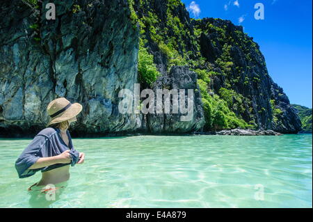 Woman standing in clear water in the Bacuit archipelago, Palawan, Philippines, Southeast Asia Stock Photo