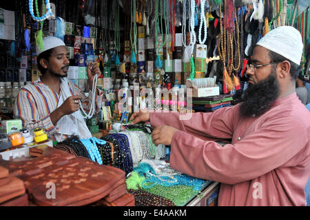 Dhaka, Bangladesh. 7th July, 2014. A customer buys jewellery at a shop during the Islamic holy month of Ramadan in Dhaka, Bangladesh, July 7, 2014. Adults and healthy Muslims are required to abstain from eating, drinking and other physical needs from dawn to dusk durign the holy month of Ramadan. © Shariful Islam/Xinhua/Alamy Live News Stock Photo