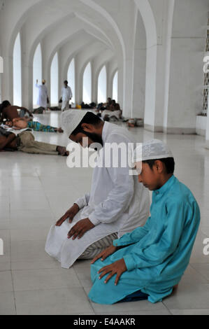 Dhaka, Bangladesh. 7th July, 2014. Bangladeshi Muslims pray at the national mosque Baitul Mokarrom during the Islamic holy month of Ramadan in Dhaka, Bangladesh, July 7, 2014. Adults and healthy Muslims are required to abstain from eating, drinking and other physical needs from dawn to dusk durign the holy month of Ramadan. © Shariful Islam/Xinhua/Alamy Live News Stock Photo