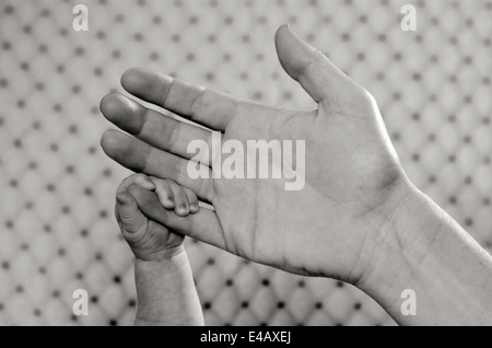 Hand of a young mother touch her newborn baby hand.(BW) copyspace