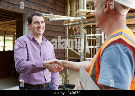 Customer Shaking Hands With Builder Stock Photo