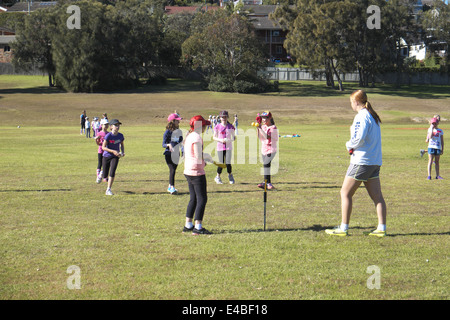 young girls learning to play softball on a winters day in narrabeen on Sydney's northern beaches,new south wales,australia Stock Photo