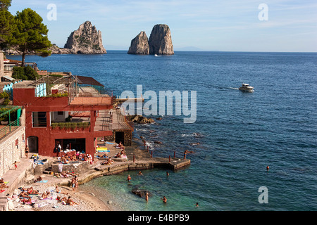 Sunbathers and swimmers with the Faraglioni Rocks in background, Marina Piccola, Capri, Campania,Italy, Europe Stock Photo