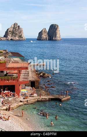 Sunbathers and swimmers with the Faraglioni Rocks in background, Marina Piccola, Capri, Campania,Italy, Europe Stock Photo