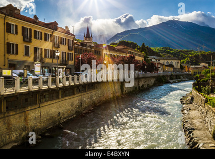 The river Dora runs through alongside the Corso Trieste in Susa, Piedmont, Italy. Stock Photo
