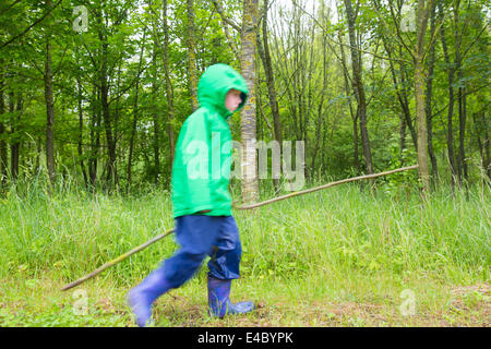 Young Boy in Woods with a Stick Stock Photo