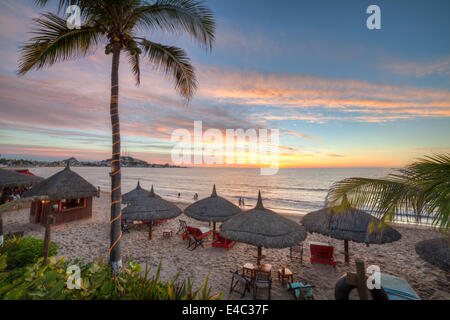 Sunset and palapas on the beach at sunset in Mazatlan, Sinaloa, Mexico. Stock Photo