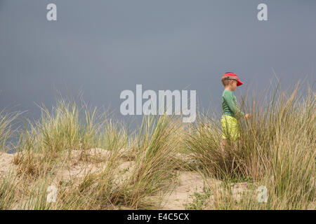 Boy wandering through the Sand Dunes, Le Touquet-Paris-Plage, France Stock Photo