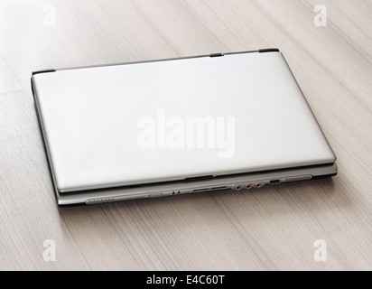 Closed laptop, on a light table Stock Photo